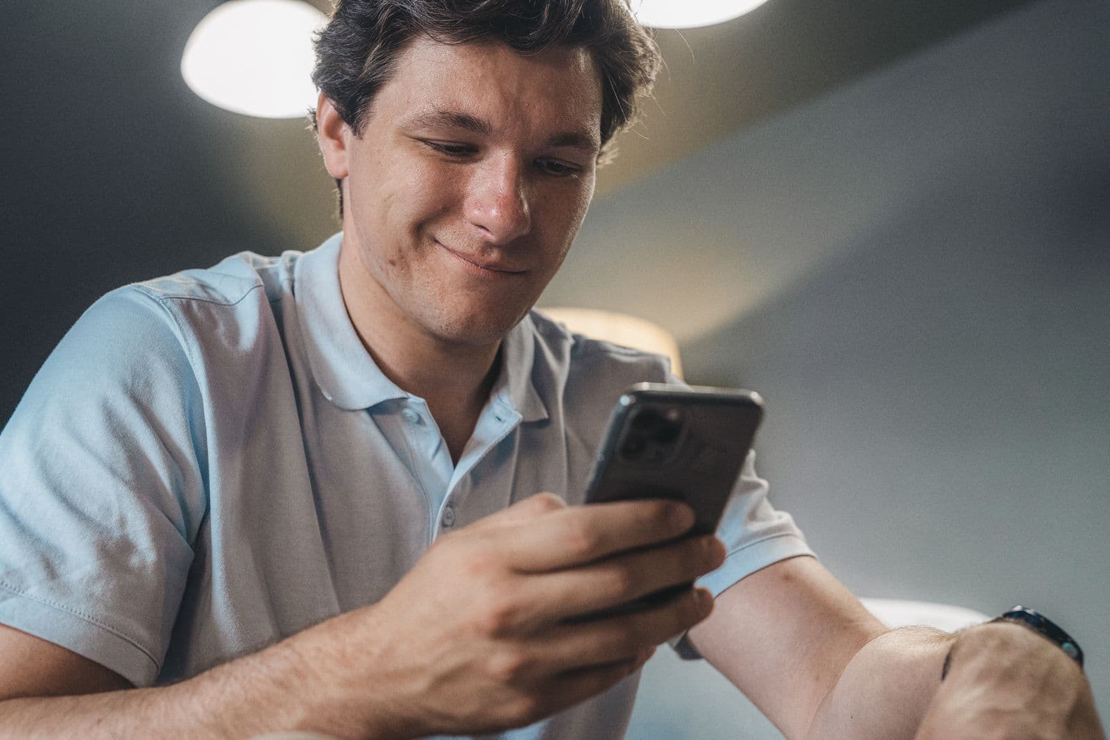 Een gast lacht terwijl hij boekt op een smartphone